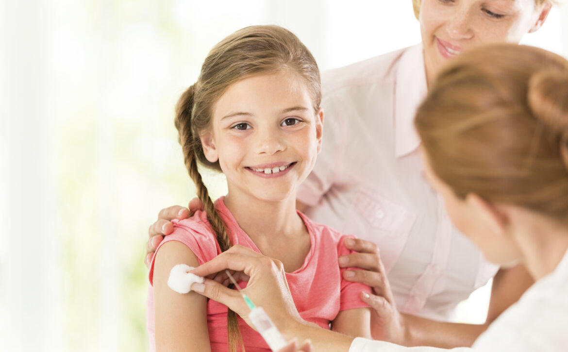 Doctor giving injection to little girl